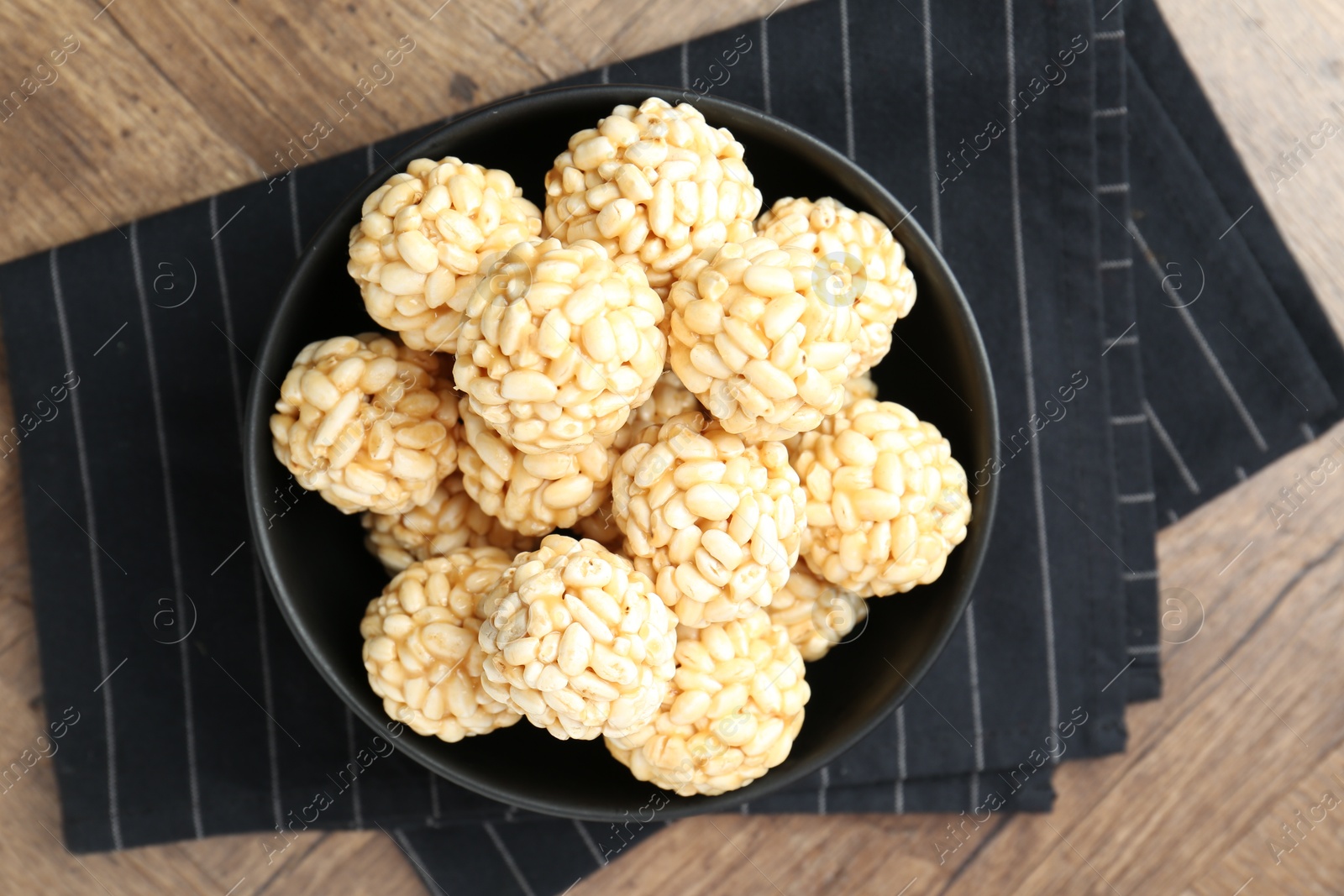 Photo of Tasty puffed rice balls on wooden table, top view