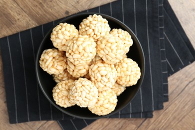 Photo of Tasty puffed rice balls on wooden table, top view