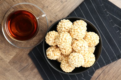 Photo of Tasty puffed rice balls and tea on wooden table, top view