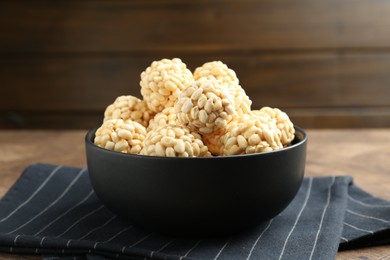 Photo of Tasty puffed rice balls in bowl on table, closeup