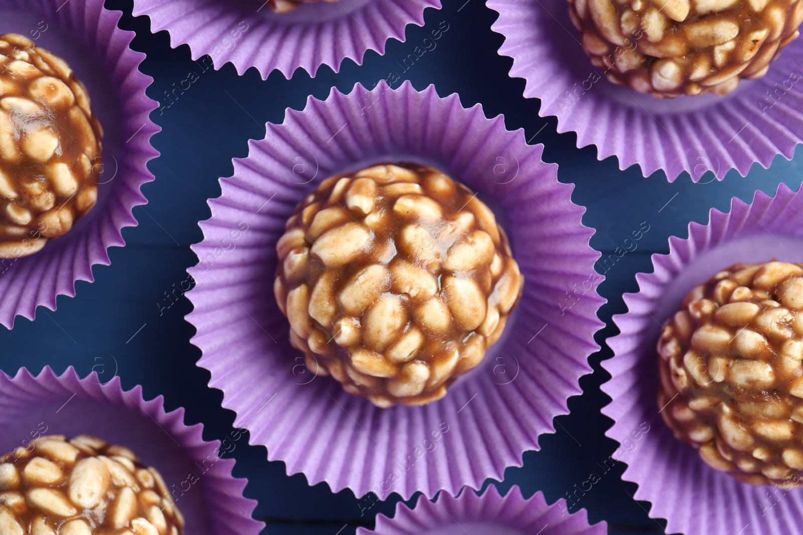 Photo of Tasty chocolate puffed rice balls on blue table, flat lay