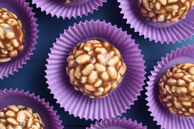 Photo of Tasty chocolate puffed rice balls on blue table, flat lay