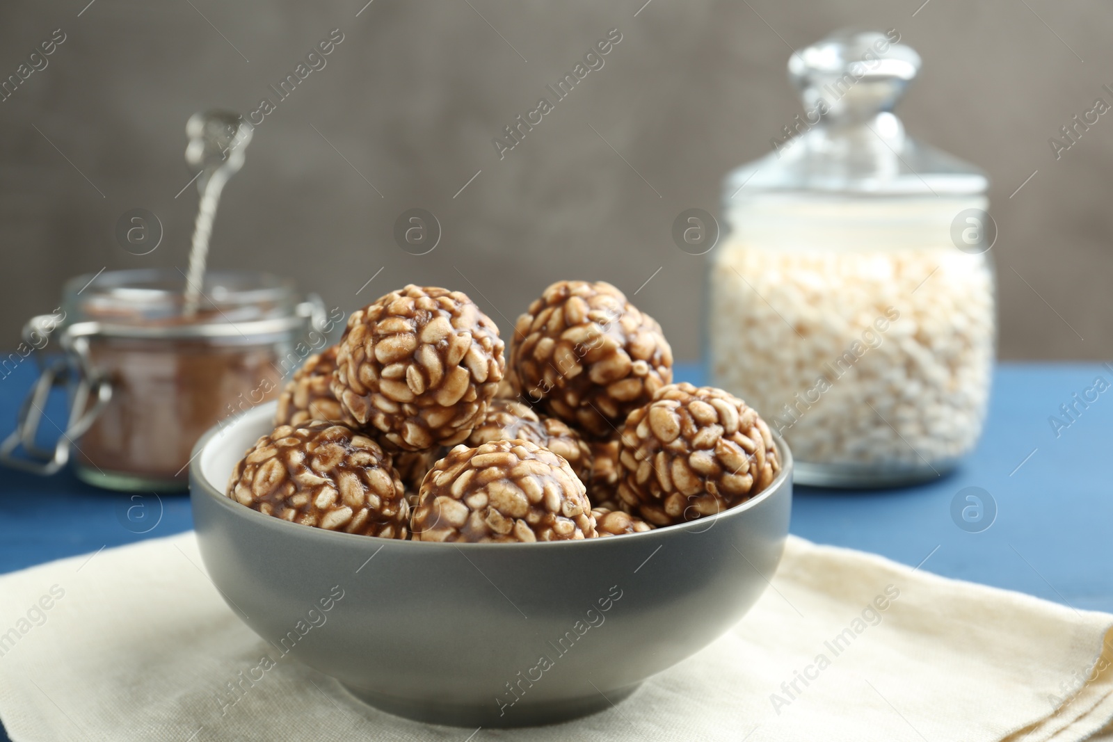 Photo of Tasty chocolate puffed rice balls in bowl on table, closeup