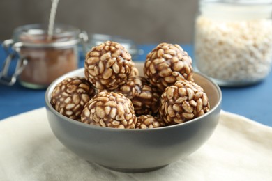 Tasty chocolate puffed rice balls in bowl on table, closeup