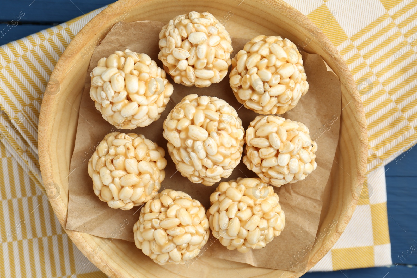 Photo of Tasty puffed rice balls on blue table, top view