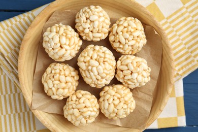 Tasty puffed rice balls on blue table, top view