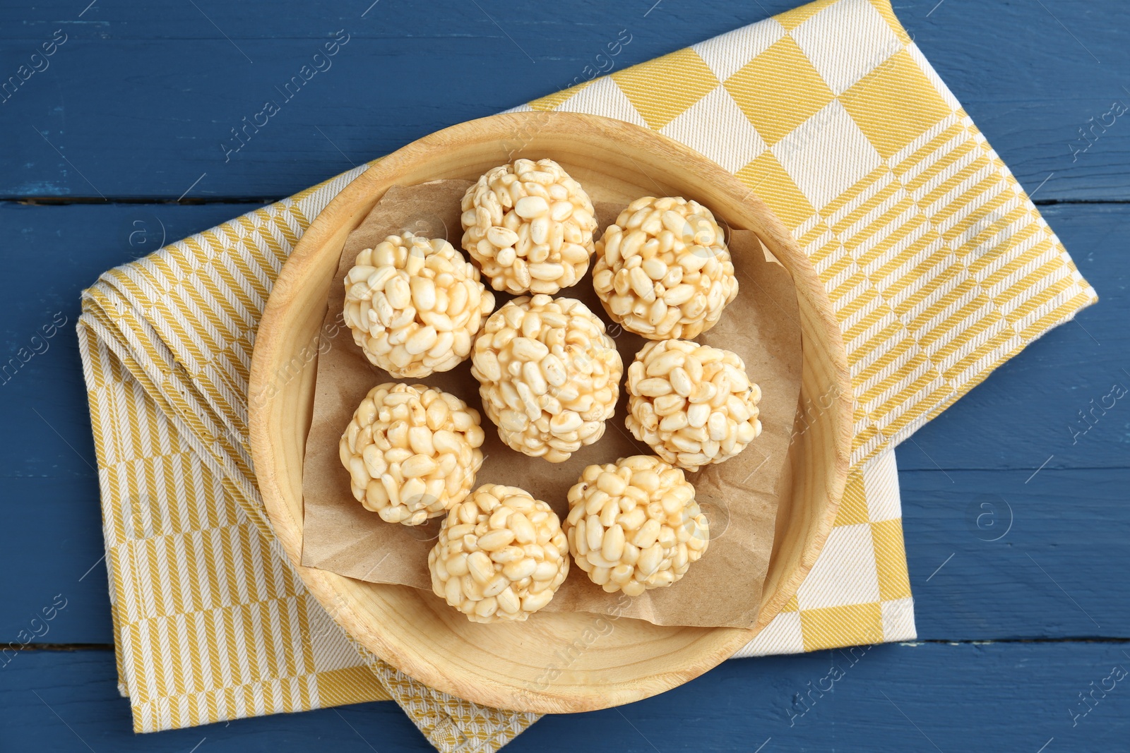 Photo of Tasty puffed rice balls on blue wooden table, top view