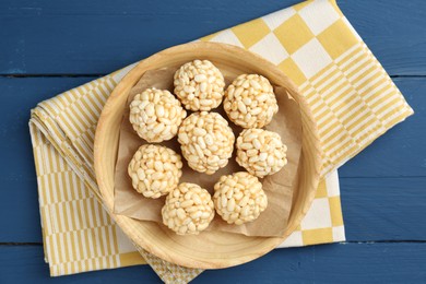 Tasty puffed rice balls on blue wooden table, top view