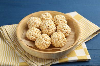 Photo of Tasty puffed rice balls on blue wooden table, closeup