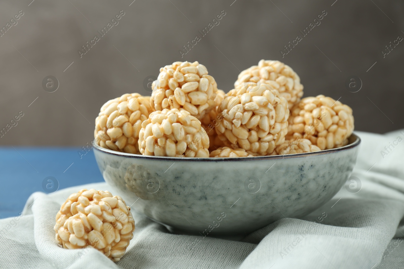 Photo of Tasty puffed rice balls in bowl on table, closeup