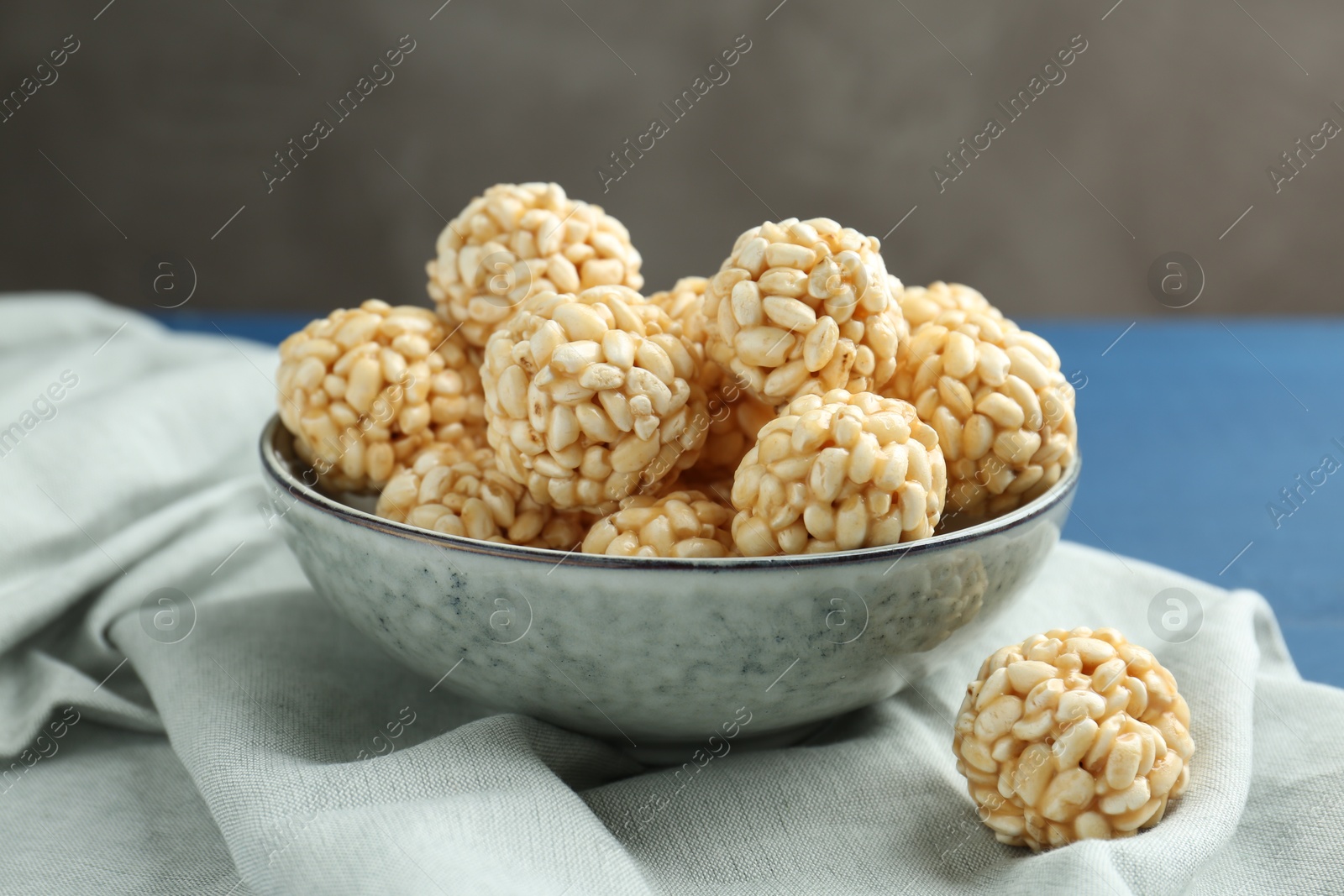 Photo of Tasty puffed rice balls in bowl on table, closeup