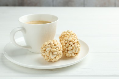 Photo of Tasty puffed rice balls and coffee on white wooden table, closeup