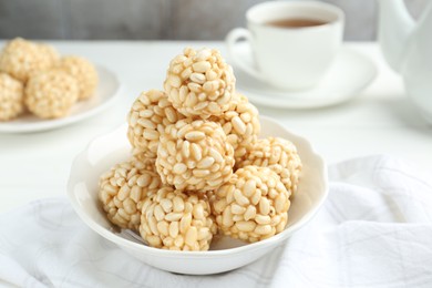 Photo of Tasty puffed rice balls in bowl on table, closeup