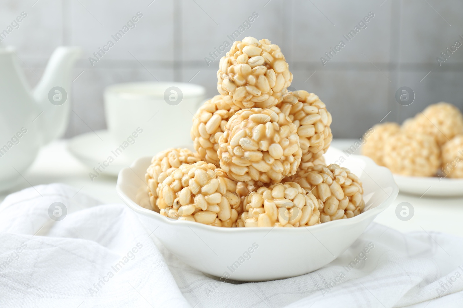 Photo of Tasty puffed rice balls in bowl on table, closeup