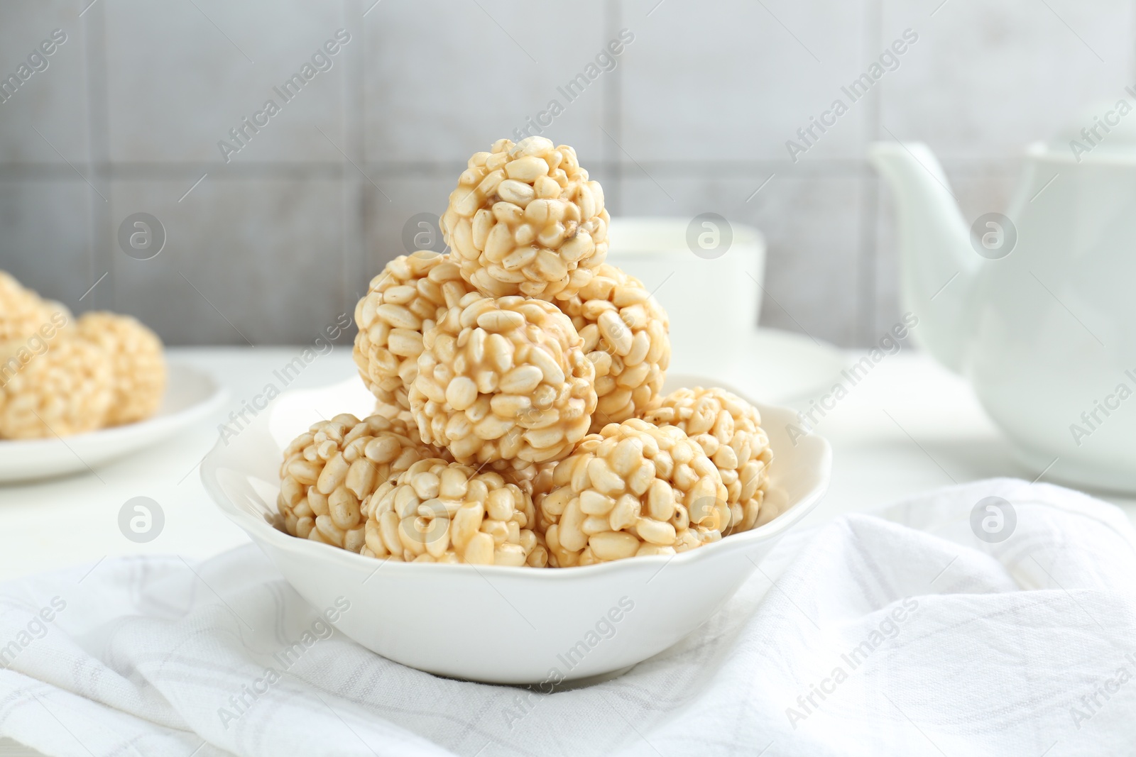 Photo of Tasty puffed rice balls in bowl on table, closeup