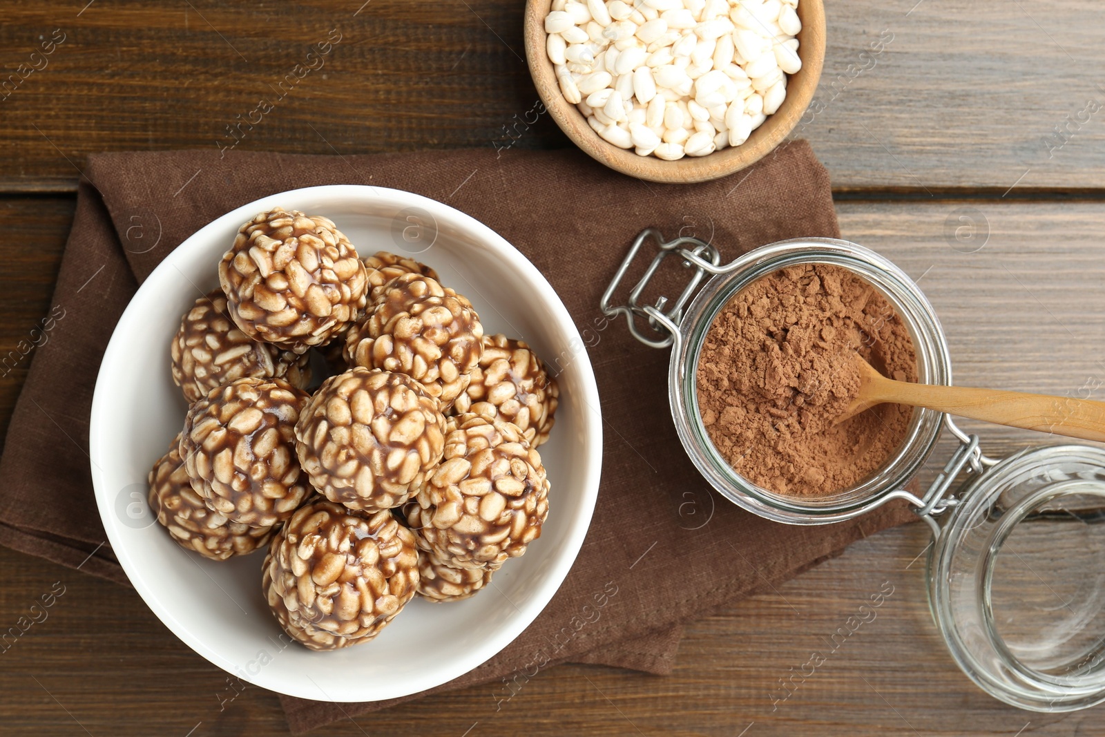 Photo of Tasty chocolate puffed rice balls and ingredients on wooden table, flat lay