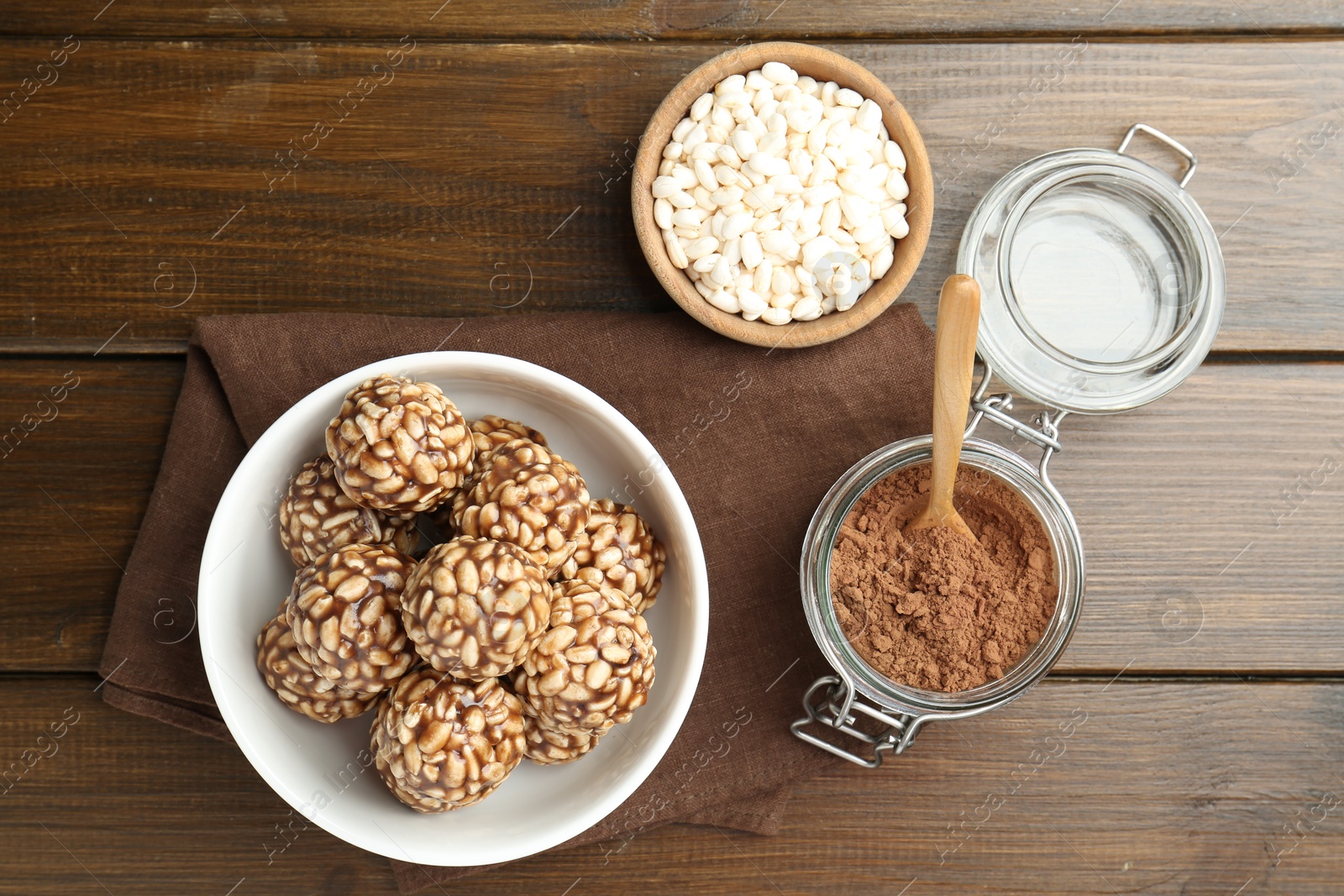 Photo of Tasty chocolate puffed rice balls and ingredients on wooden table, flat lay