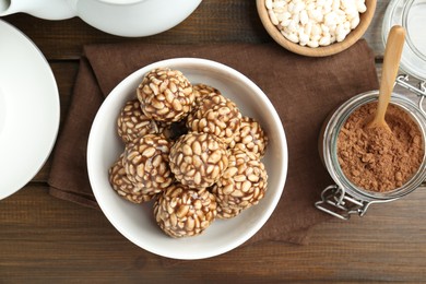 Photo of Tasty chocolate puffed rice balls served on wooden table, flat lay