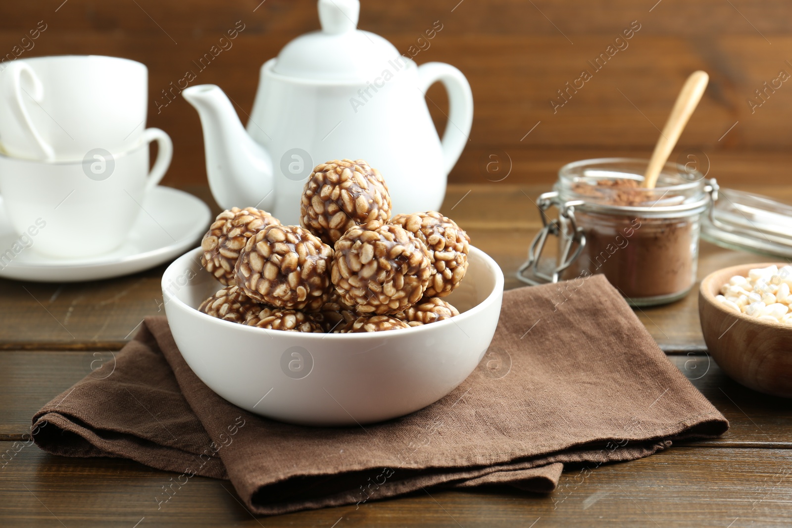 Photo of Tasty chocolate puffed rice balls served on wooden table