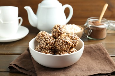 Tasty chocolate puffed rice balls served on wooden table, closeup