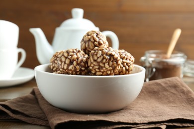 Photo of Tasty chocolate puffed rice balls in bowl on table, closeup