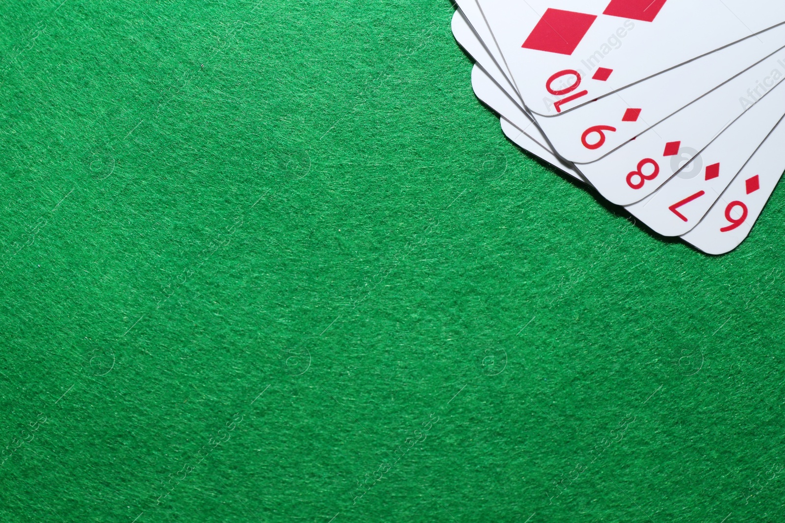 Photo of Poker game. Playing cards on green table, flat lay. Space for text