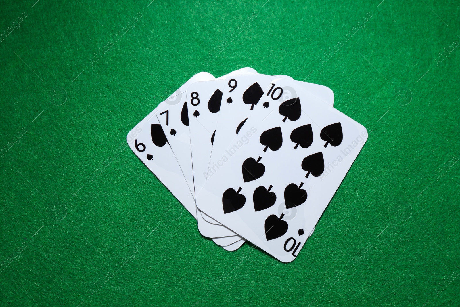 Photo of Poker game. Playing cards on green table, flat lay