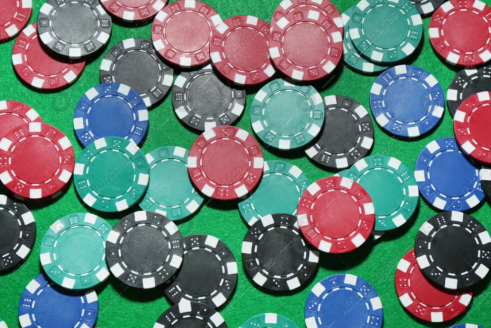 Photo of Poker chips on green table, flat lay