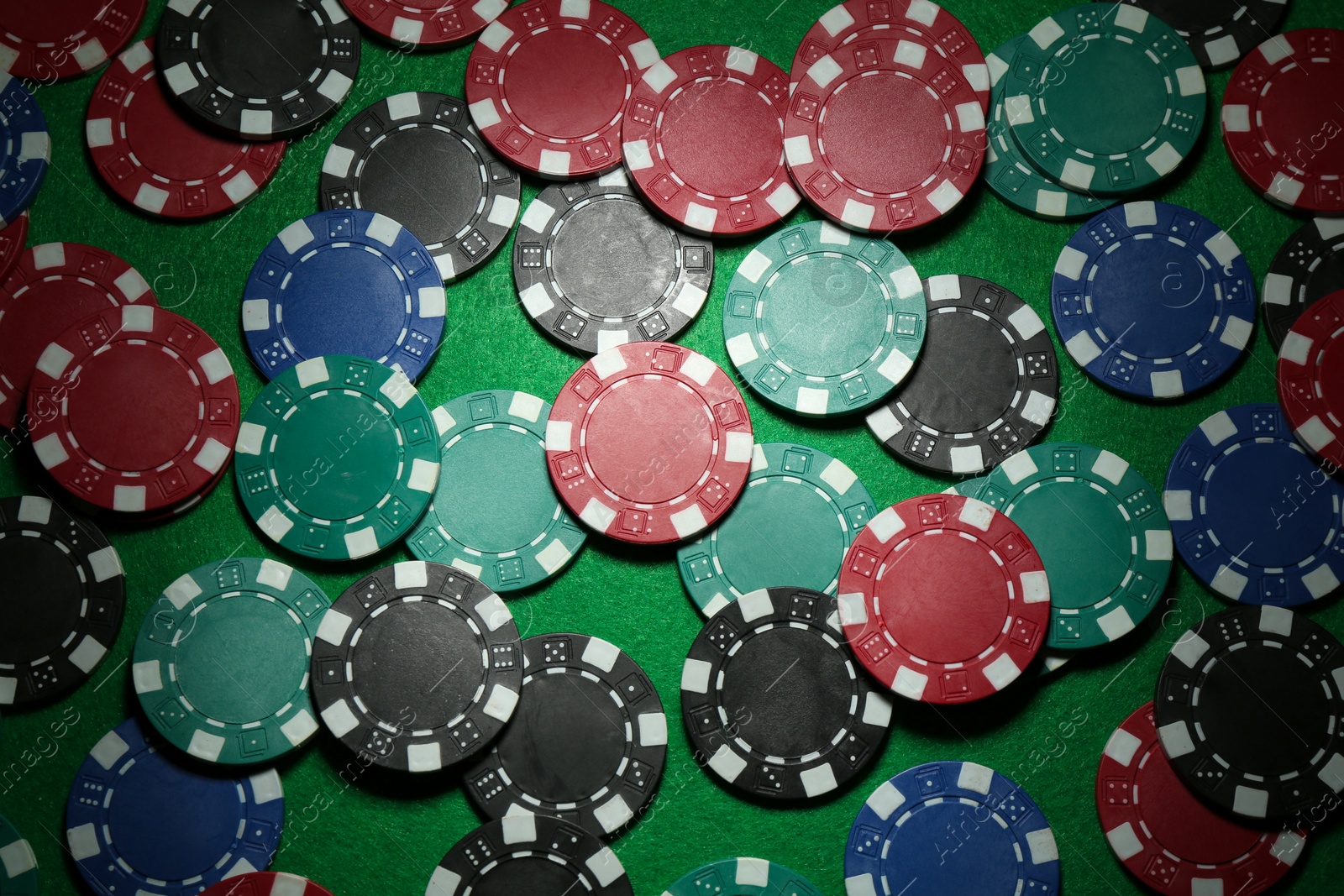 Photo of Poker chips on green table, flat lay