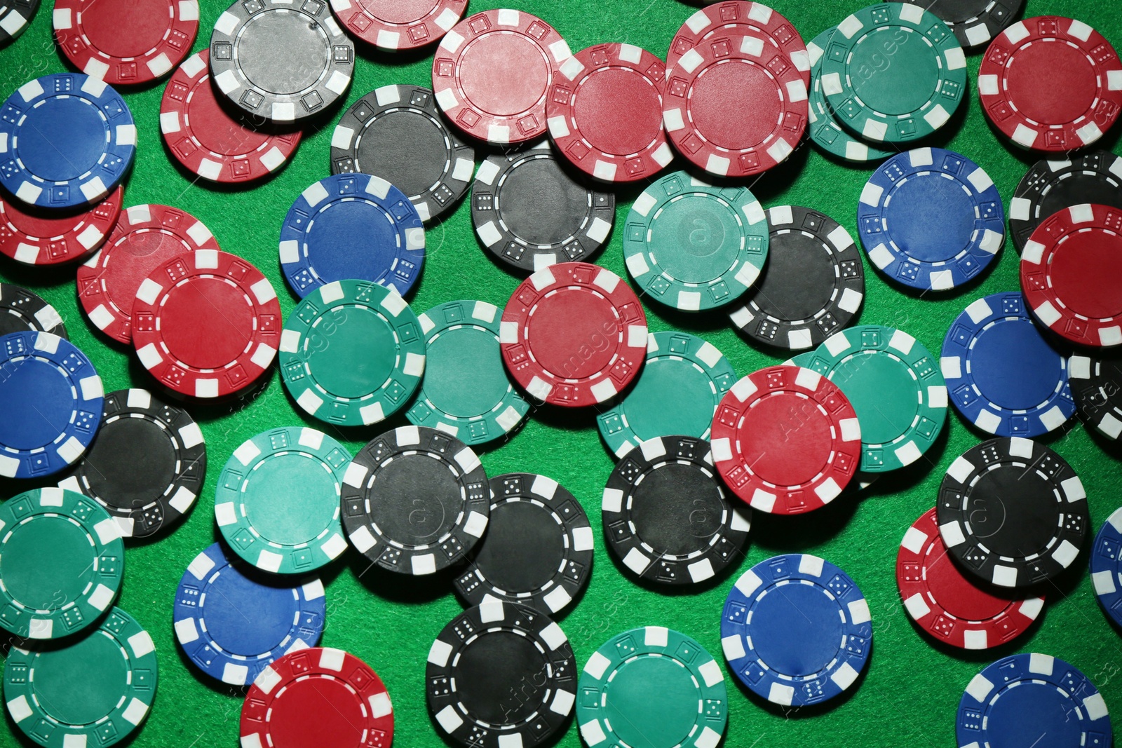 Photo of Poker chips on green table, flat lay