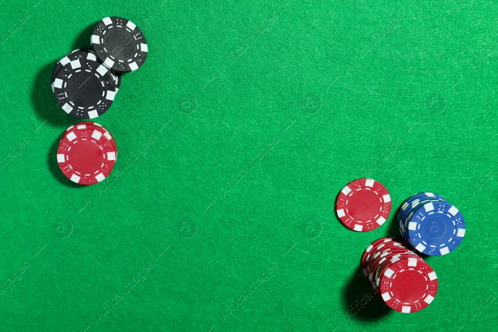 Photo of Poker chips on green table, flat lay. Space for text