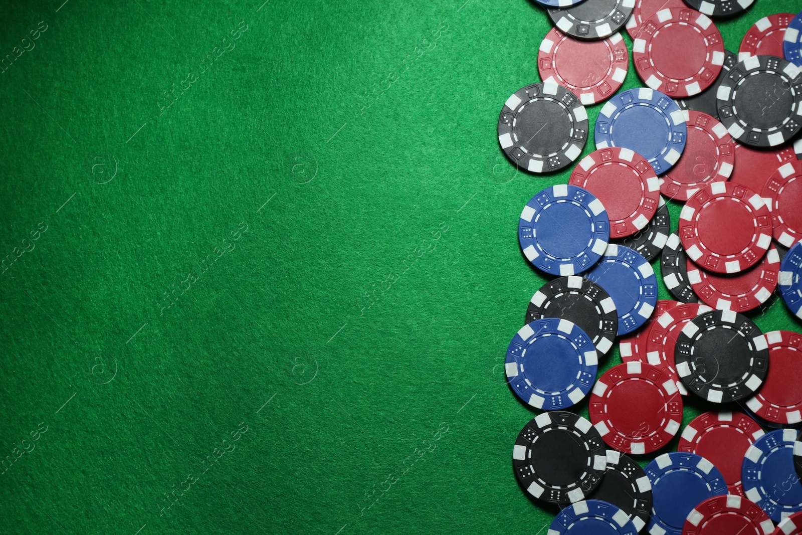 Photo of Poker chips on green table, flat lay. Space for text