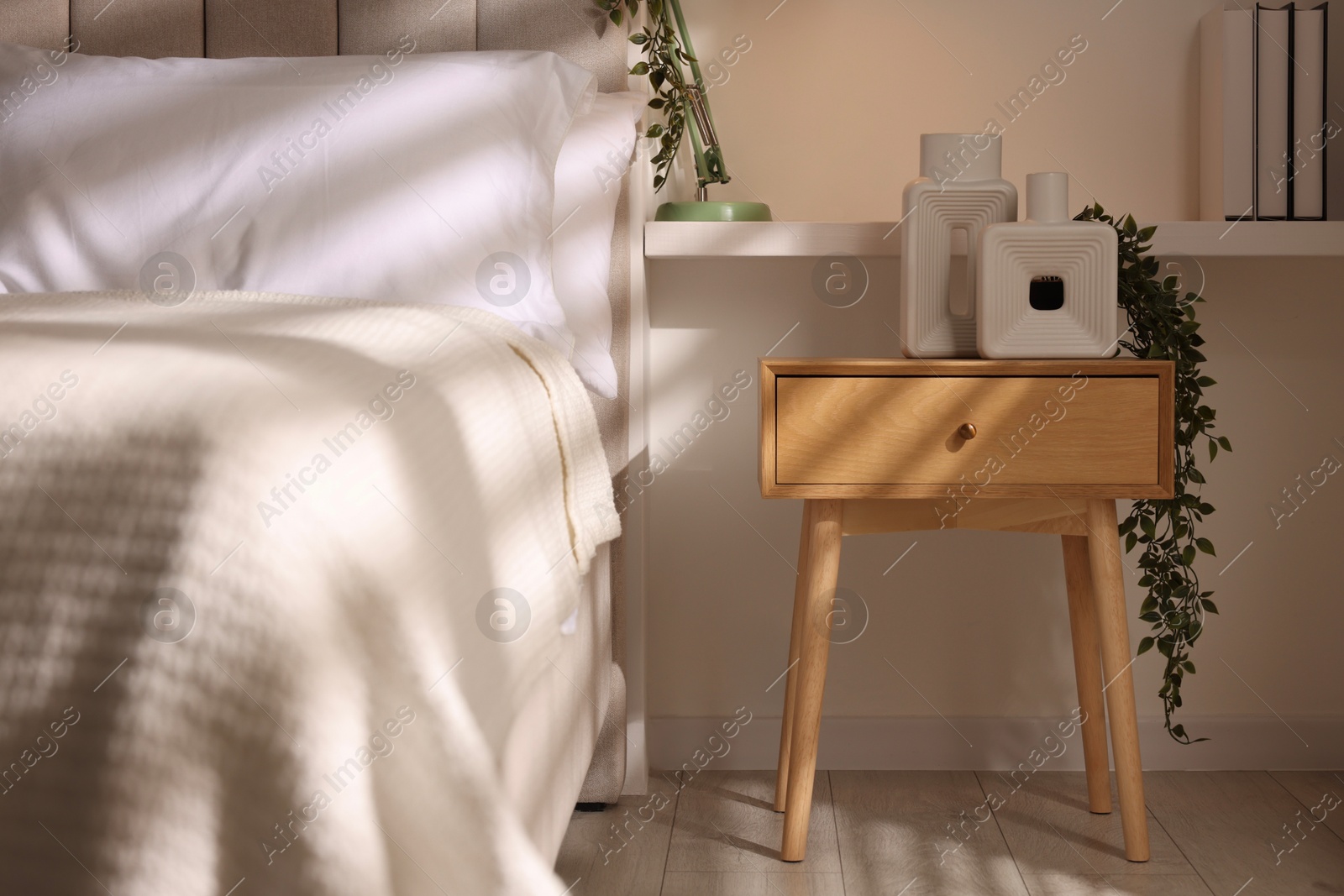 Photo of Stylish living room interior with bed, bedside table and lamp