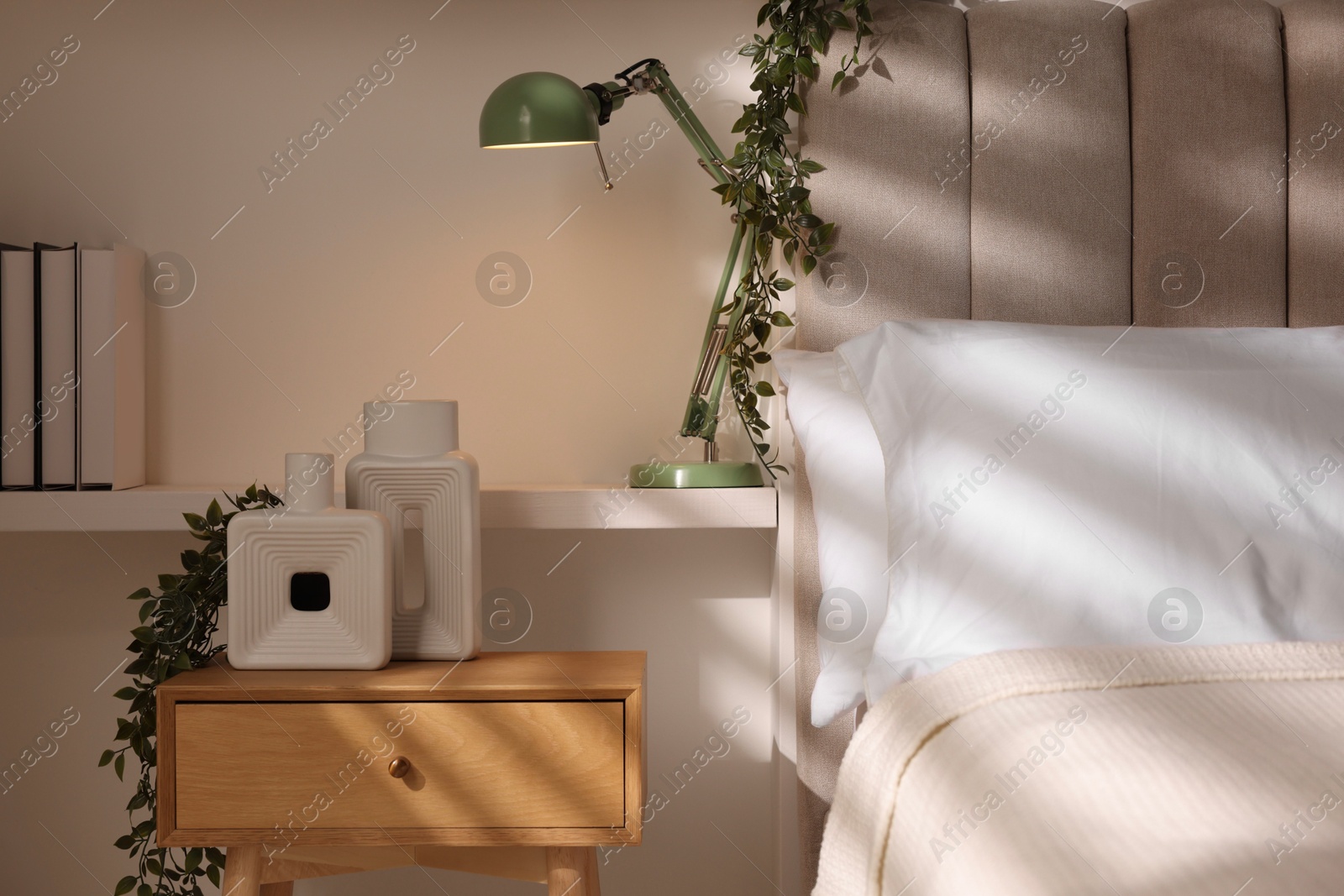 Photo of Stylish living room interior with bed, bedside table and lamp