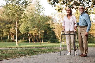 Photo of Senior couple with walking frame in park