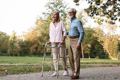 Photo of Senior couple with walking frame in park