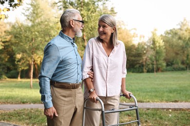 Photo of Senior couple with walking frame in park