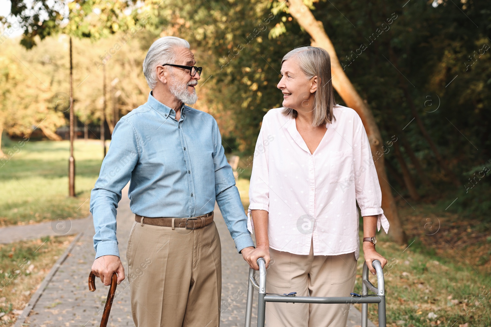 Photo of Senior couple with walking frame and cane in park