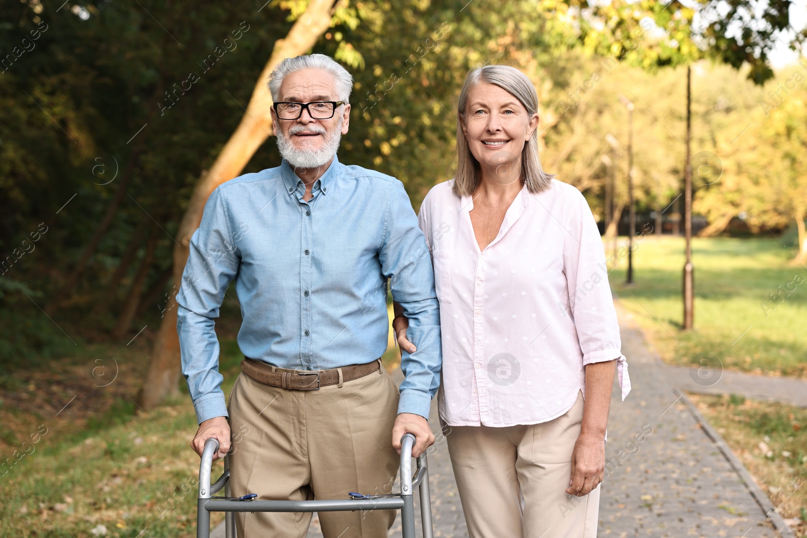 Photo of Senior couple with walking frame in park