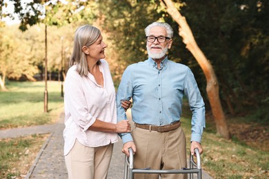 Photo of Senior couple with walking frame in park