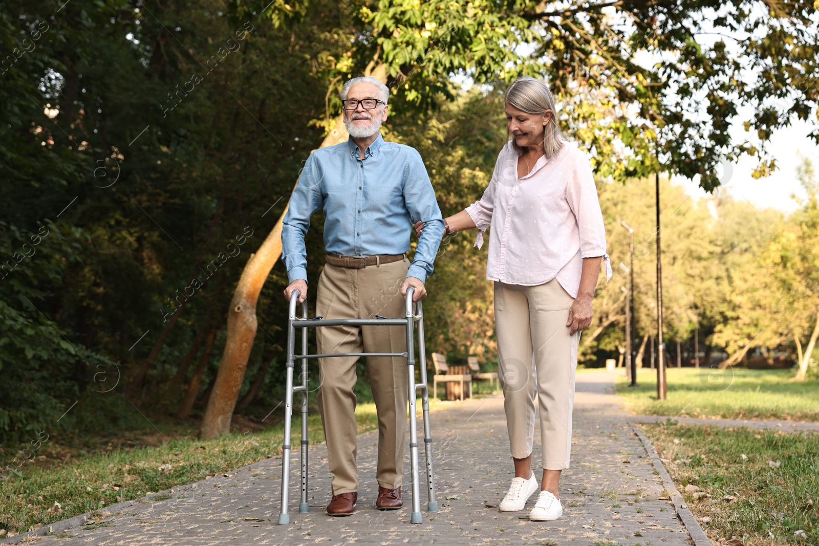 Photo of Senior couple with walking frame in park