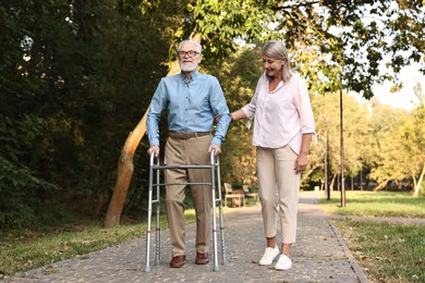 Photo of Senior couple with walking frame in park