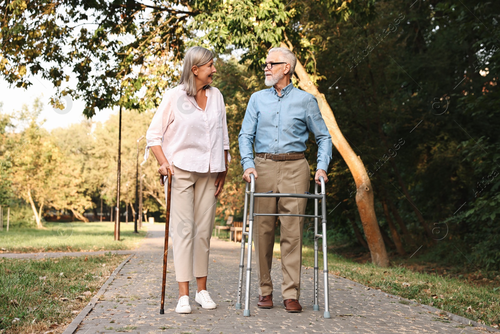 Photo of Senior couple with walking frame in park