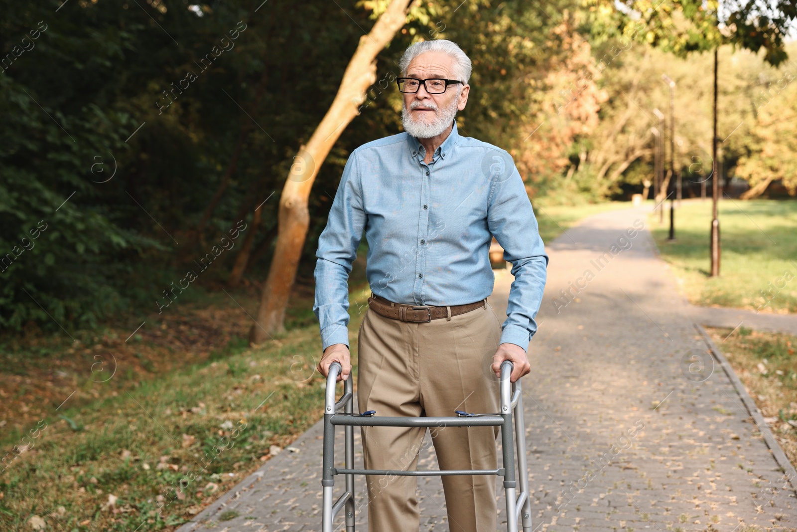 Photo of Senior man with walking frame in park