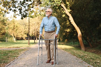 Photo of Senior man with walking frame in park