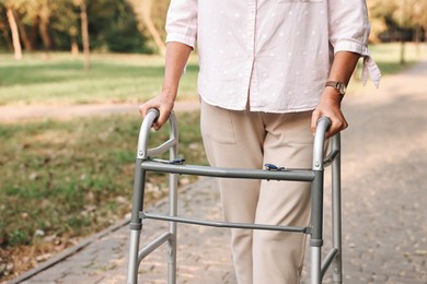 Photo of Senior woman with walking frame in park, closeup