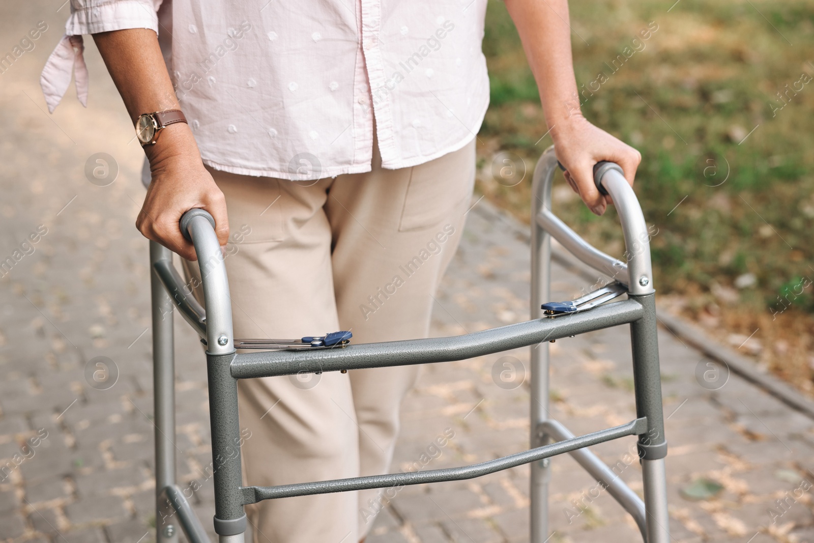 Photo of Senior woman with walking frame in park, closeup