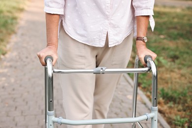 Senior woman with walking frame in park, closeup