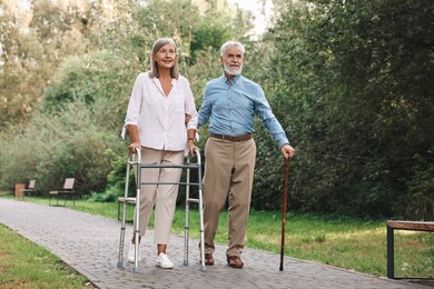 Photo of Senior couple with walking frame and cane in park