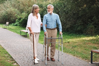 Photo of Senior couple with walking frame and cane in park